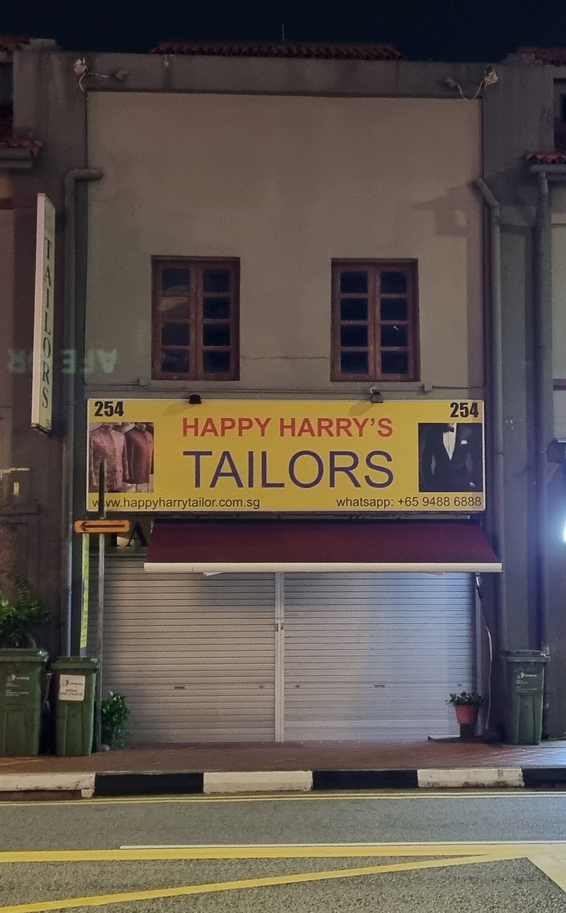 The yellow Happy Harry's Tailors signboard at 254 South Bridge Road